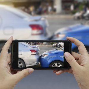 Close up hand holding smartphone and take photo at The scene of a car crash and Rear-End Collisions